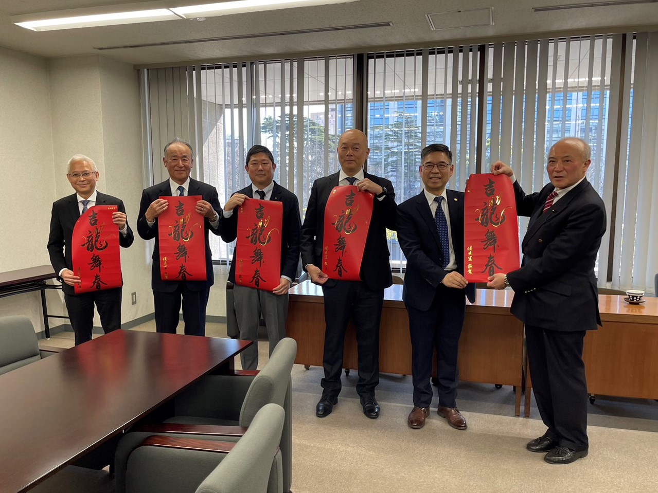 副秘書長柯慶忠(右二)致贈新北市府龍年春聯給縣議員川村博章(右一)及千葉中華總會成員