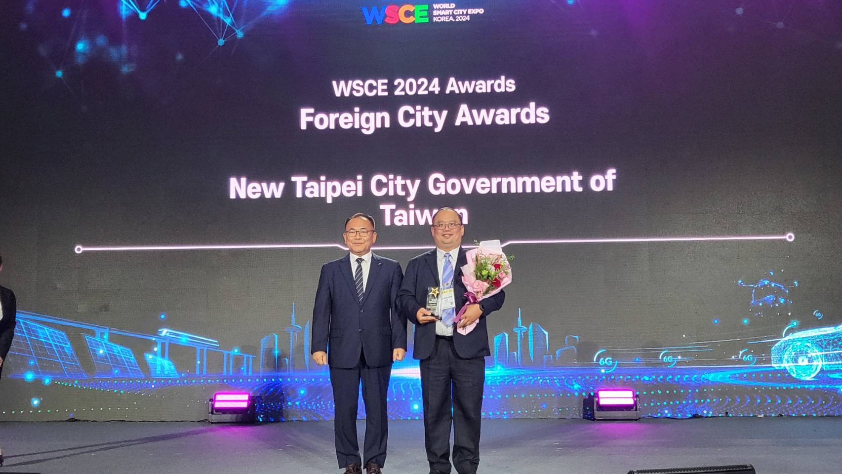 新北市政府出席「2024 WSCE世界智慧城市博覽會暨頒獎典禮」，由資訊中心陳富添主任(右)代表領獎