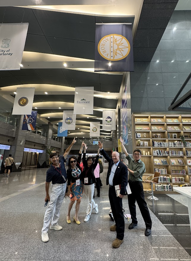 Aurora Mayor Mike Coffman (second from right) poses with the Aurora flag in the main hall of the New Taipei City Hall.