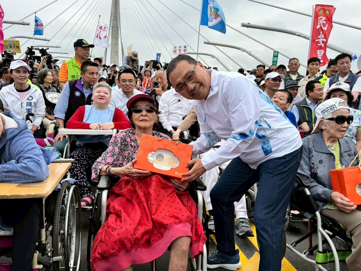 新北市長侯友宜與多位在地耆老共同登橋,其中,高齡百歲的人瑞阿嬤用歲月見證了淡水從歷史古鎮走向現代永續城市的蛻變,讓這場登橋活動更具意義