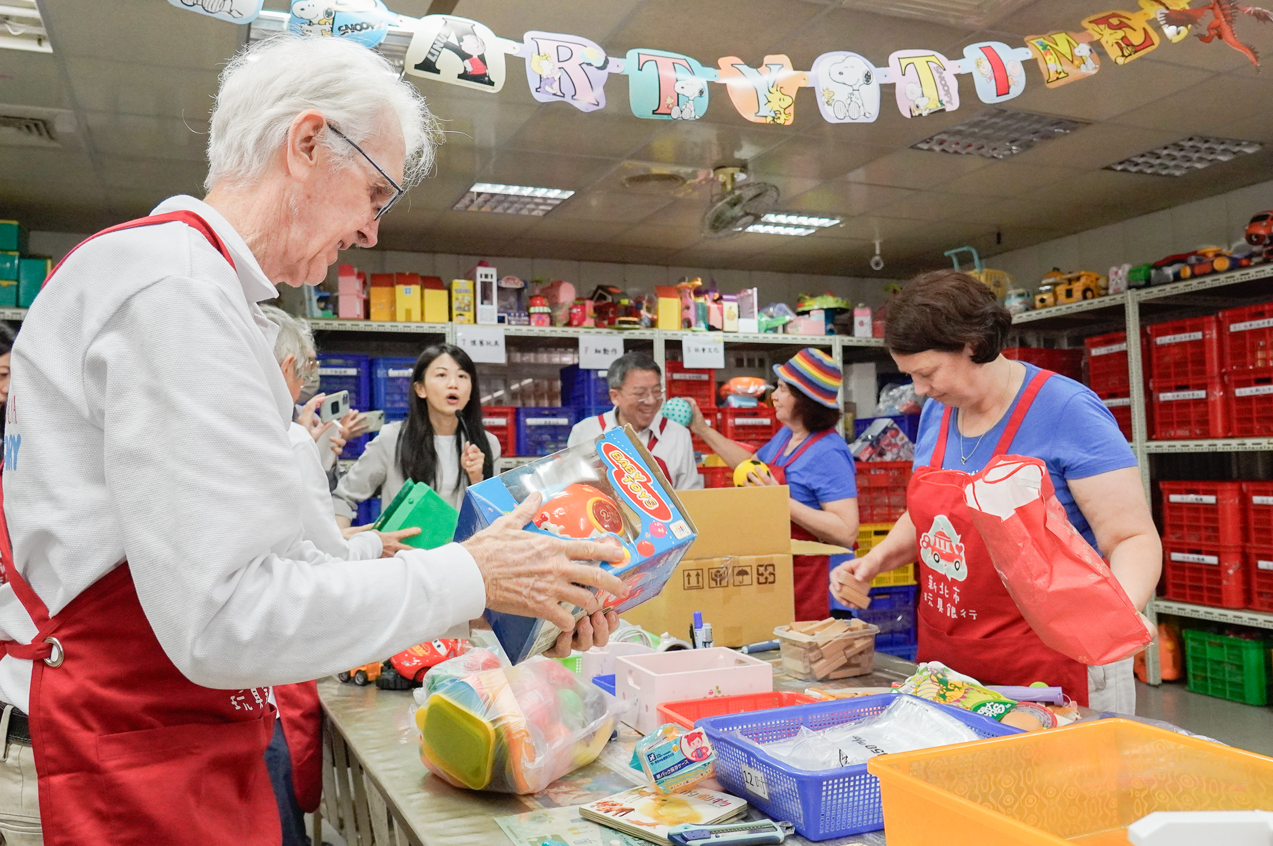 澳洲參訪團穿起玩具銀行紅色的志工服，一起體驗回收、分類和整理