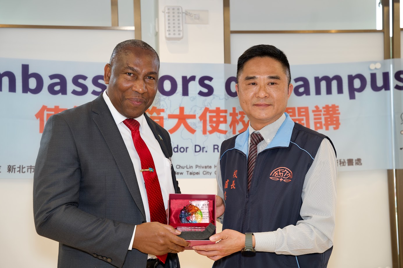 Chih-Hsiung Lu, Principal of Chu-Lin Private High School, presents a Chulin Paperweight as a commemorative gift to Lewis.